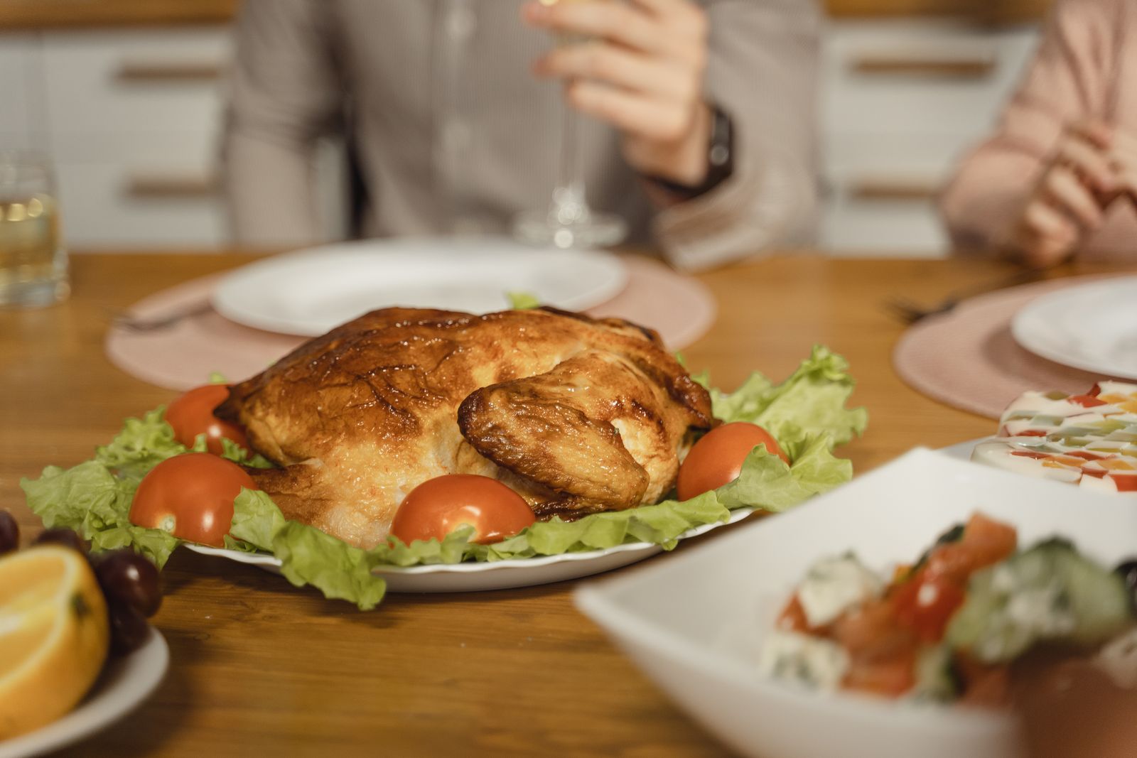 Frango assado servido em prato branco com acompanhamentos
